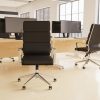 office chair black leather with chrome frame and arms in front of office desk in room shot