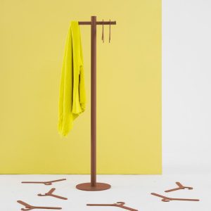 contemporary coat stand in brown finish in front of yellow wall