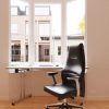 high back executive office chair in black leather in room set in front of desk by window