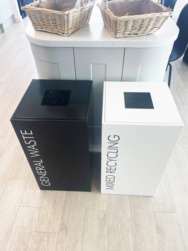 office recycling bins in white and black finish in front of retail unit.