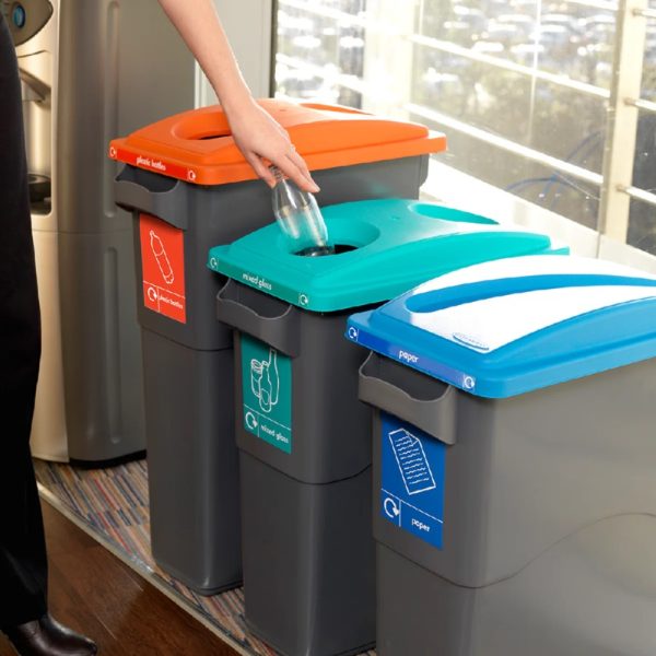 office recycling bins in a row for different waste streams. black with different coloured tops and labelling,