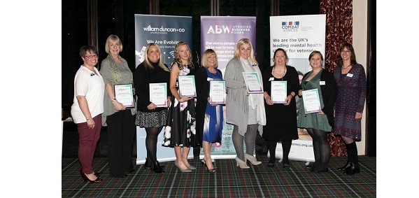 ladies standing in a row with award certificates