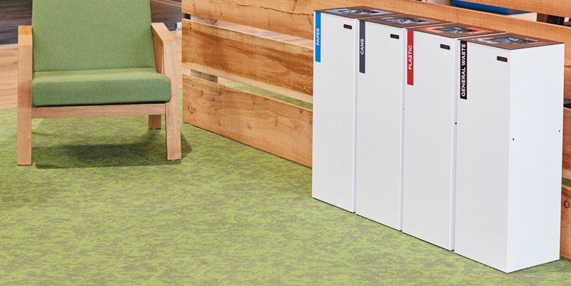 row of white office recycling bins and chair