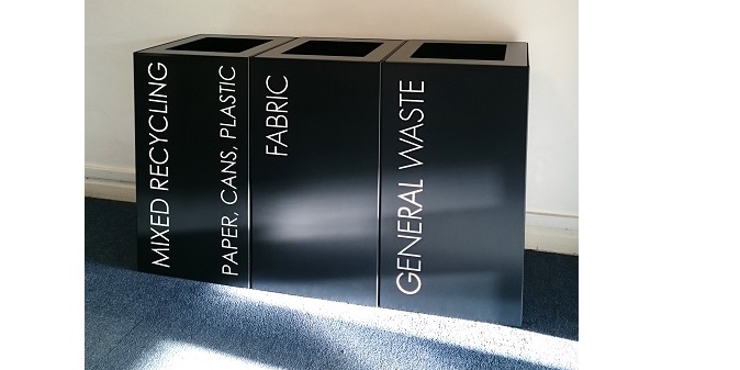 row of black office recycling bins with white lettering