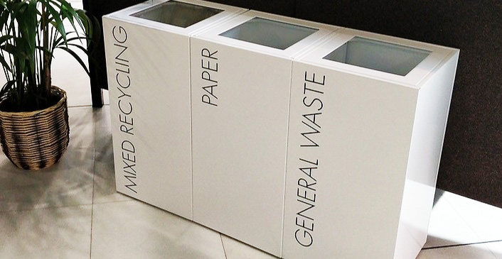 row of white office recycling bins with black lettering Mixed Recycling, Paper and General Waste