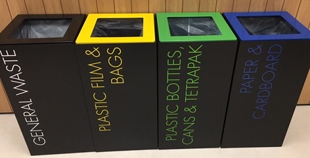 office recycling bins black with coloured tops and labelling to indicate waste stream