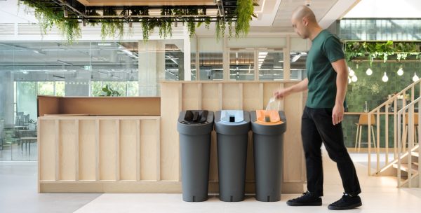 office recycling bin in row of three with marking for waste stream. in restaurant room shot