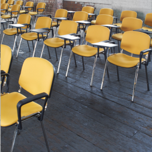 training room with rows of training room chairs with yellow fabric seats and tablets